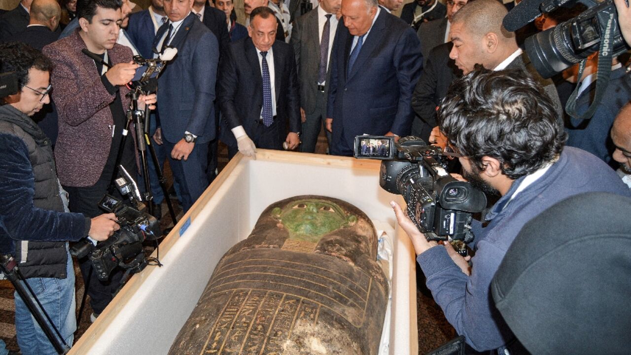 Egypt's Foreign Minister Sameh Shoukry (C-R) and the head of the Supreme Council of Antiquities Mostafa Waziri (C-L) inspect the "Green Sarcophagus"