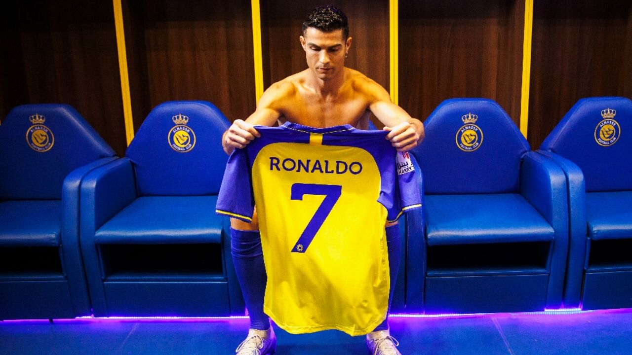 An Al-Nassr handout photo shows Cristiano Ronaldo preparing to put on his club shirt before being introduced to fans at the club's Mrsool Park stadium