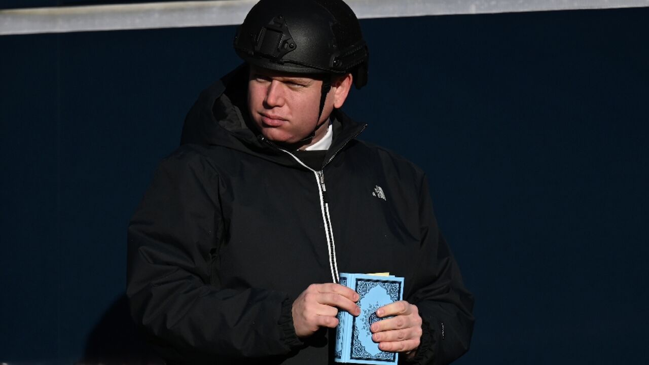 Far-right activist Rasmus Paludan holds a Koran before he burns it near a mosque in Copenhagen