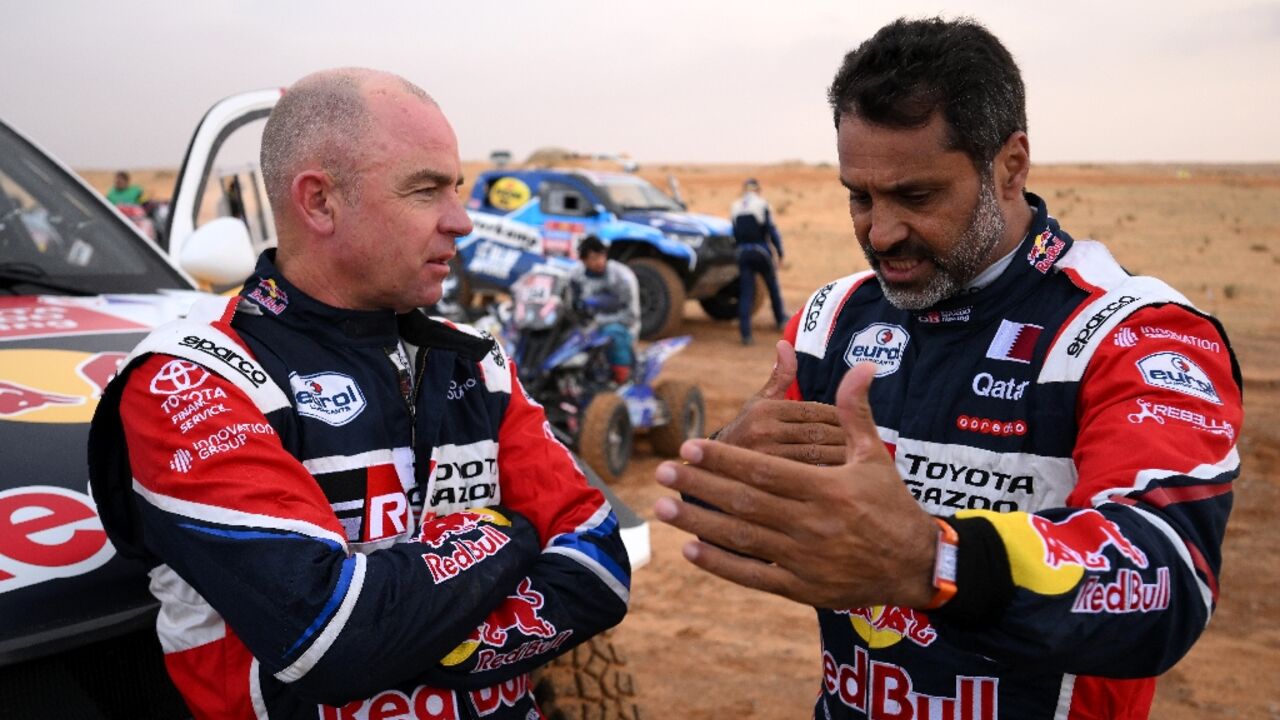 Nasser Al-Attiyah (R), who stops the standings in the cars, with Giniel De Villiers after Tuesday's rain-affected stage Nasser Al-Attiyah (R), who stops the standings in the cars, with Giniel De Villiers after Tuesday's rain-affected stage