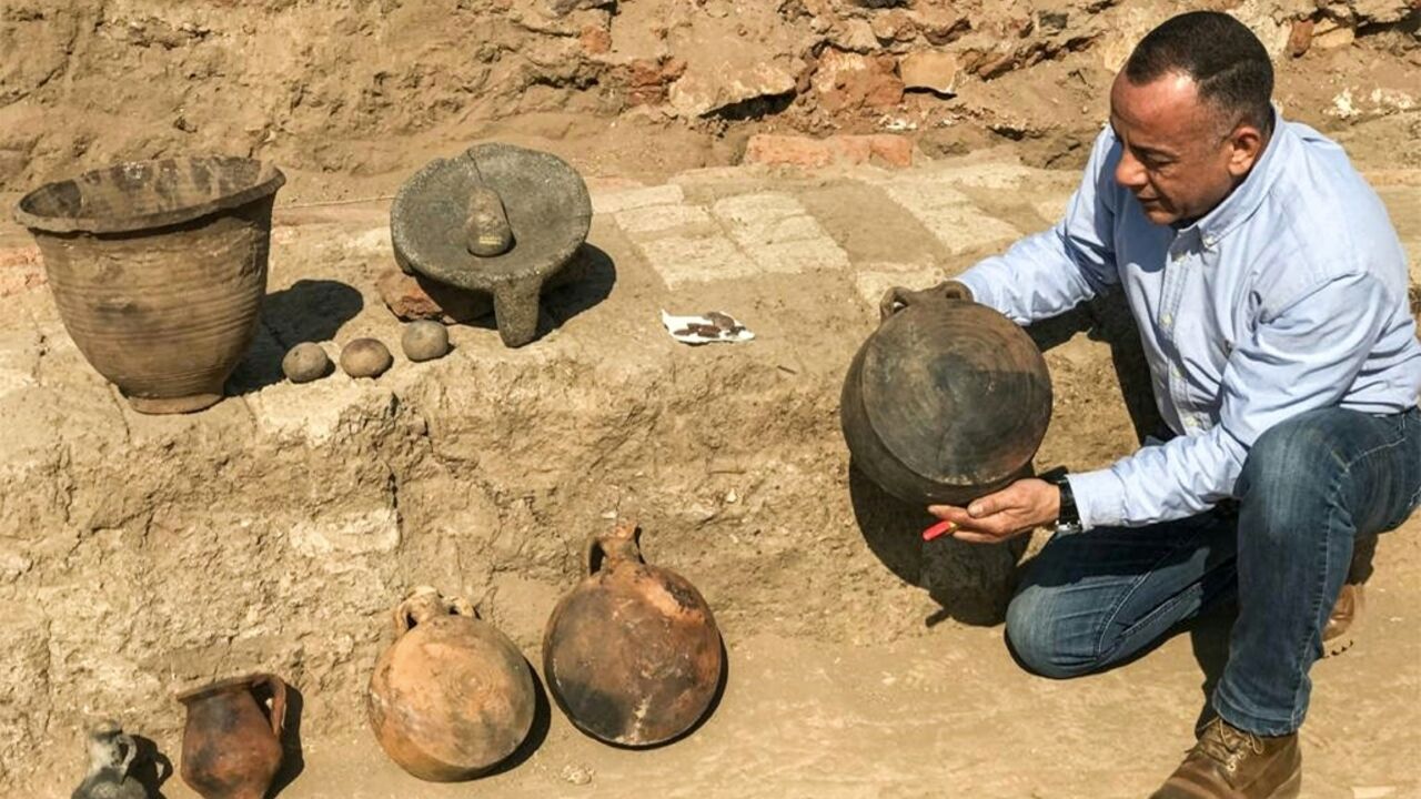 Mostafa Waziri, the head of Egypt's Supreme Council of Antiquities, inspects a pot discovered at a 1,800-year-old Roman-era city, as seen in this photograph from the Egyptian Ministry of Antiquities