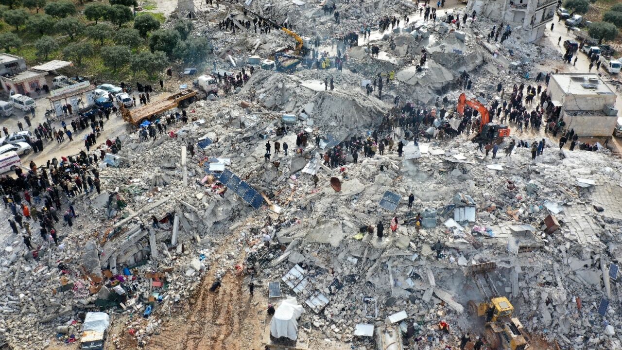 An aerial view of residents searching for survivors in the Syrian village of Besnia in rebel-held Idlib province