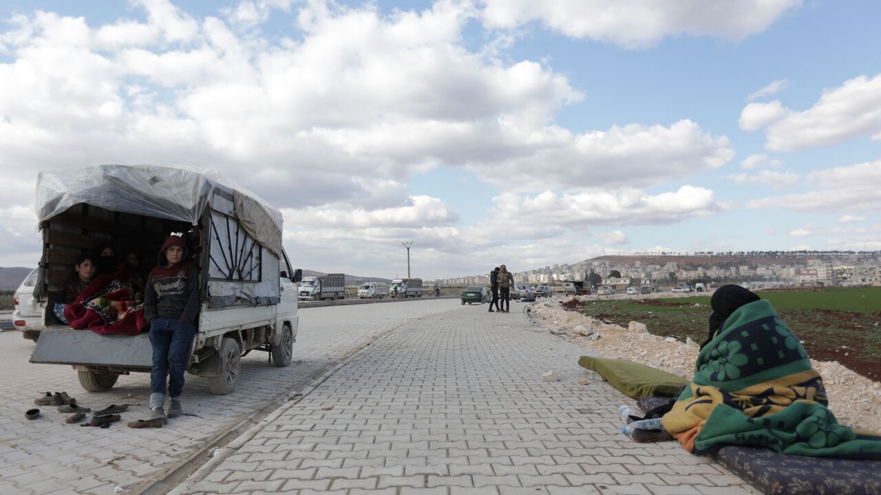 Syrians, displaced as a result of the deadly earthquake that hit Turkey and Syria two days ago, arrive to an open area on the outskirts of the rebel-held town of Jindayris on February 8, 2023. - A leading United Nations official called for the facilitation of aid access to rebel-held areas in Syria's northwest, warning that relief stocks will soon be depleted. Rebel-held areas near Turkey's border -- hard hit by the 7.8 magnitude earthquake that struck on Monday -- cannot receive aid from government-held pa