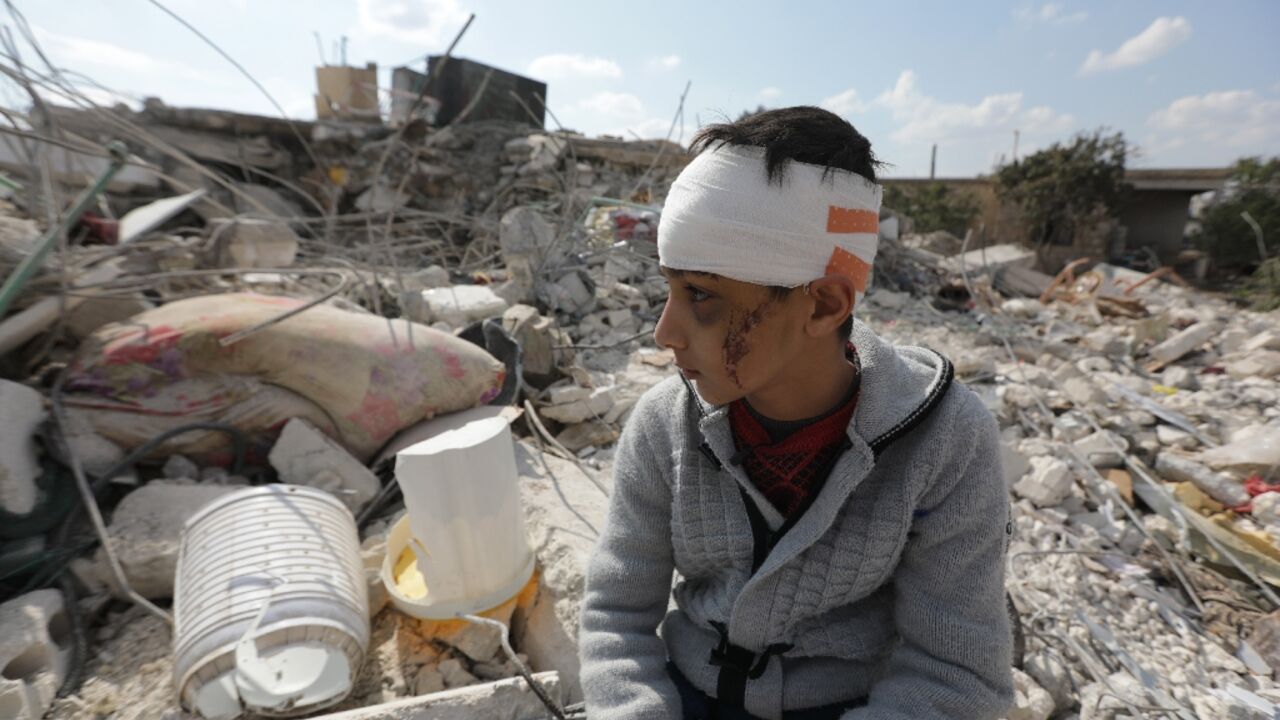 A Syrian boy sits amid the rubble of his family home in Jindayris, in the rebel-held part of Syria's Aleppo