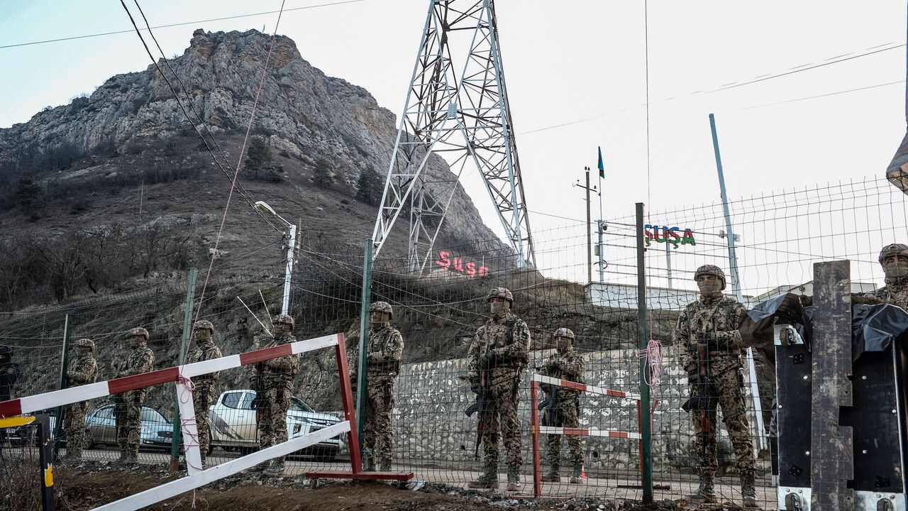 Azerbaijani servicemen stand guard at a checkpoint at the Lachin corridor, the Armenian-populated breakaway Nagorno-Karabakh region's only land link with Armenia, as Azerbaijani environmental activists protest what they claim is illegal mining, on December 26, 2022.