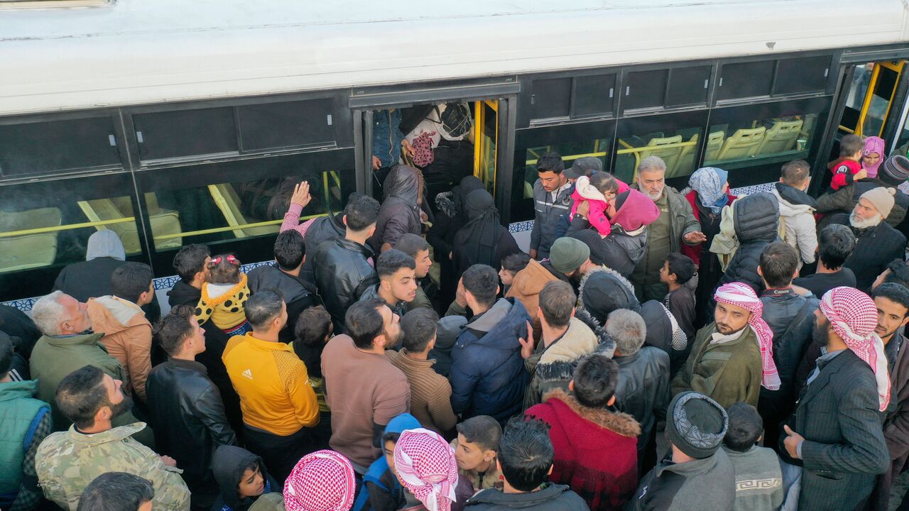 An aerial picture shows Syrian refugees living in Turkey waiting to take a bus through the northern Bab al-Hawa border crossing, on February 17, 2023, as they return to Syria in the aftermath of a deadly earthquake. - Turkey this week allowed Syrians under its protection who hold ID cards from one of the quake-hit provinces to leave for between three and six months, a rule change designed to reunite families on both sides of the border hit by the February 6 disaster, which has killed more than 41,000 people