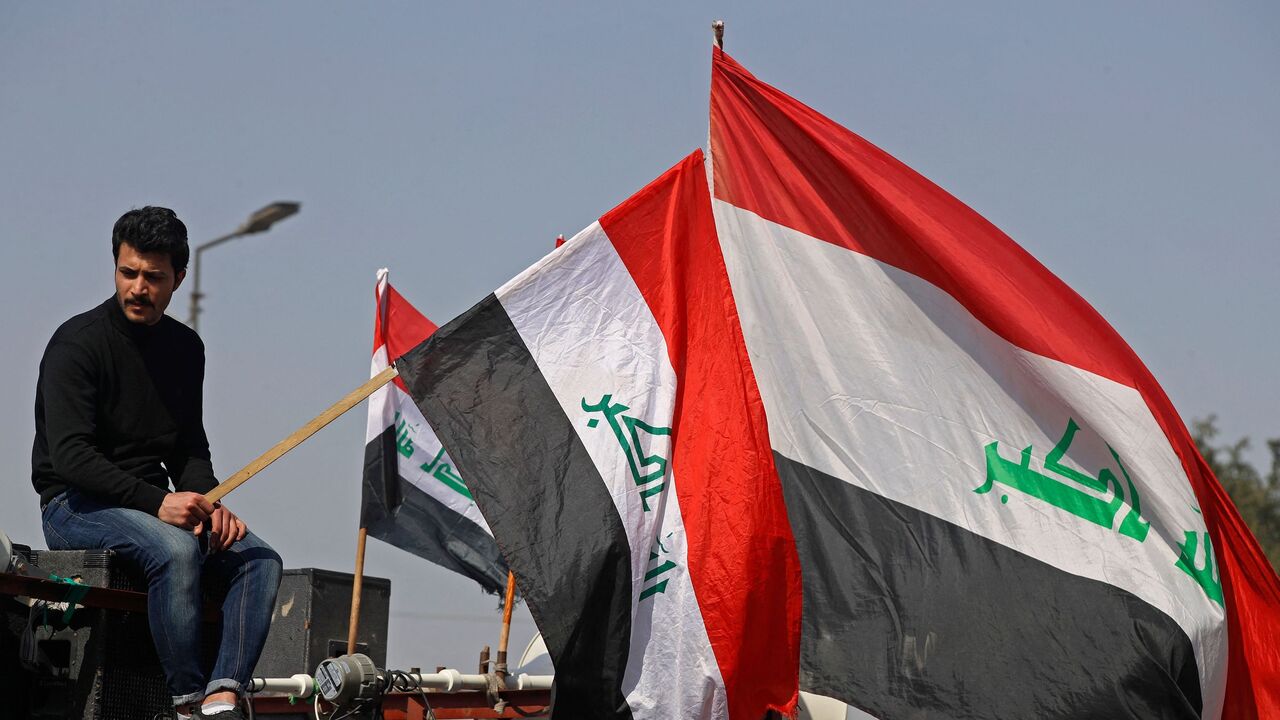 Demonstrators lift national flags during a protest near Baghdad's Green Zone on February 27, 2023.