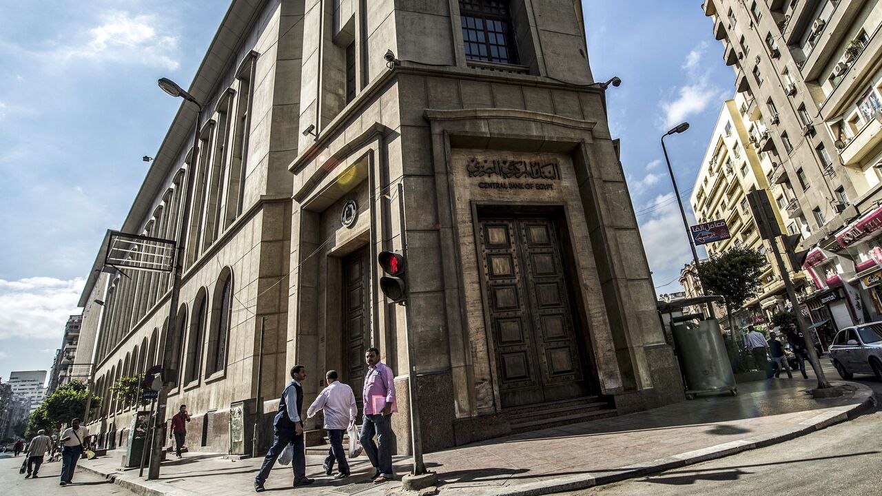 People walk past the Egyptian Central Bank in downtown Cairo on November 3, 2016. - Egypt floated the country's pound as part of a raft of reforms, after a dollar crunch and exorbitant black market trade threatened to grind some imports to a halt. (Photo by KHALED DESOUKI / AFP) (Photo by KHALED DESOUKI/AFP via Getty Images)