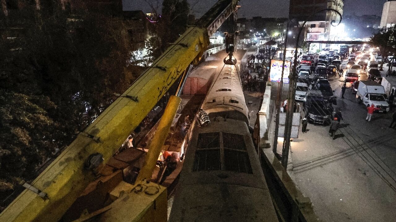 A crane is deployed to lift a derailed train at the scene of a railroad accident in the city of Qalyub in Qalyub province, in Egypt's Nile delta region