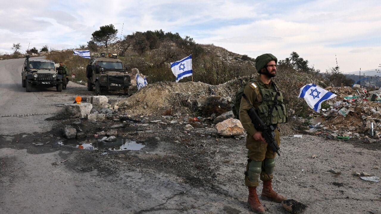 Israeli soldiers guard the road leading to the Homesh Yeshiva (religious school), at the former settlement of Homesh, December 30, 2021 Israeli soldiers guard the road leading to the Homesh Yeshiva (religious school), at the former settlement of Homesh, December 30, 2021