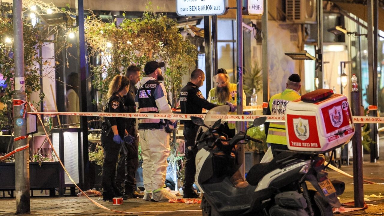 Israeli police, forensics experts, and paramedics at the scene of a shooting attack along Tel Aviv's Dizengoff Avenue 