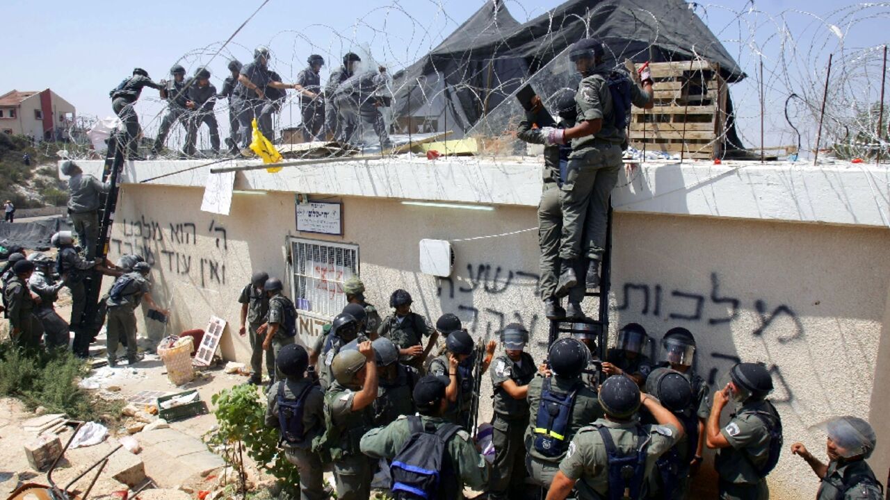 Israeli soldiers forcibly evict residents of the Jewish settlement of Homesh in 2005, one of four settlements evacuated alongide Israel's withdrawal from the Gaza Strip