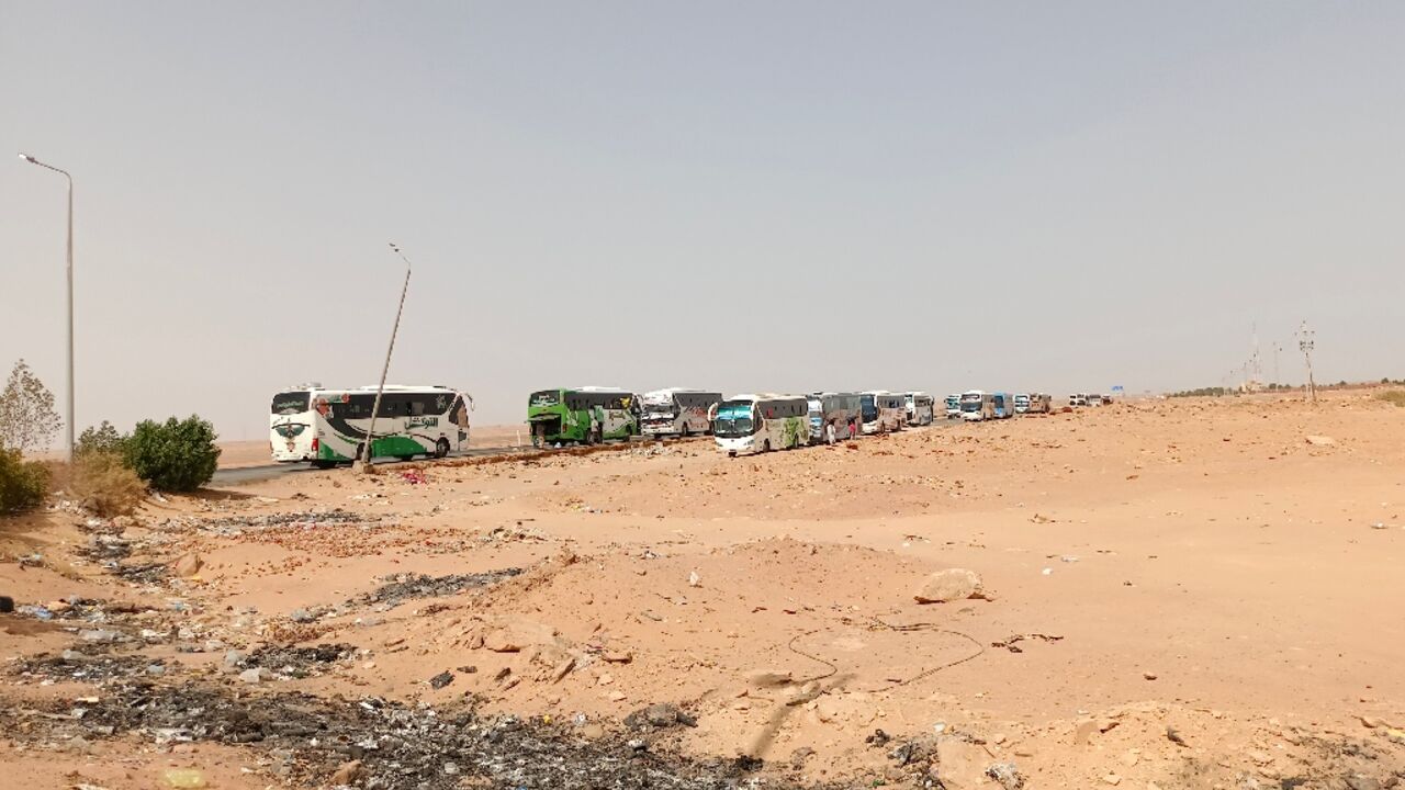 A bus convoy from war-torn Sudan arrives at the Wadi Karkar bus station near the Egyptian city of Aswan, on April 25, 2023