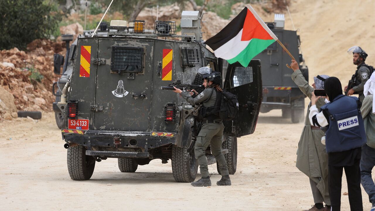 An Israeli soldier takes aim during a protest by Palestinians in the village of Beita, south of Nablus in the occupied West Bank, on April 10, 2023, against a march by settlers to the nearby Israeli outpost of Eviatar. (Photo by JAAFAR ASHTIYEH / AFP) (Photo by JAAFAR ASHTIYEH/AFP via Getty Images)