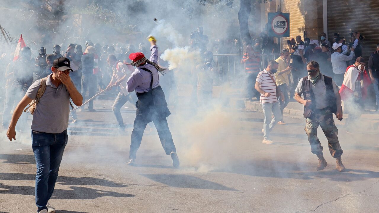 A Lebanese demonstrator returns a tear gas canister that was fired by security forces during a protest demanding better pay and living conditions in the capital Beirut on April 18, 2023. - Lebanese security forces fired tear gas at protesters demonstrating in Beirut on Wednesday against deteriorating living conditions, as the currency plummeted to new lows against the dollar. (Photo by ANWAR AMRO / AFP) (Photo by ANWAR AMRO/AFP via Getty Images)