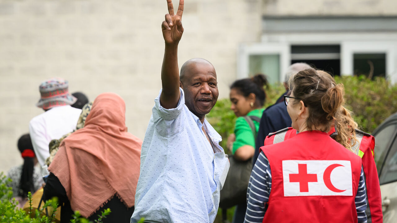 A man gestures towards the media as people arrive at Stansted Airport from Sudan on April 27, 2023 in Stansted, Essex. The British government has coordinated a series of evacuation flights of British nationals from Khartoum, during a short ceasefire between rival military factions. (Photo by Leon Neal/Getty Images)