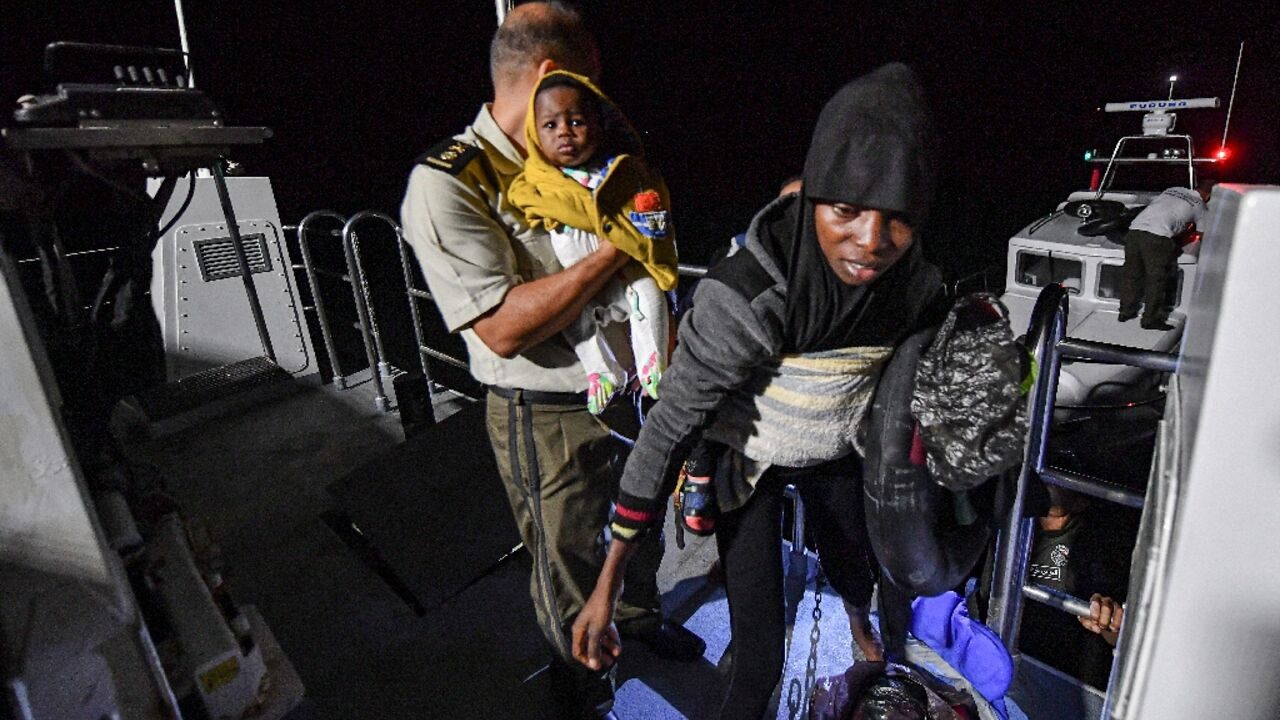 Migrants are rescued off their boat by the Tunisian National Guard about 50 nautical miles in the Mediterranean sea off the coast of Tunisia's central city of Sfax on October 4, 2022 Migrants are rescued off their boat by the Tunisian National Guard about 50 nautical miles in the Mediterranean sea off the coast of Tunisia's central city of Sfax on October 4, 2022