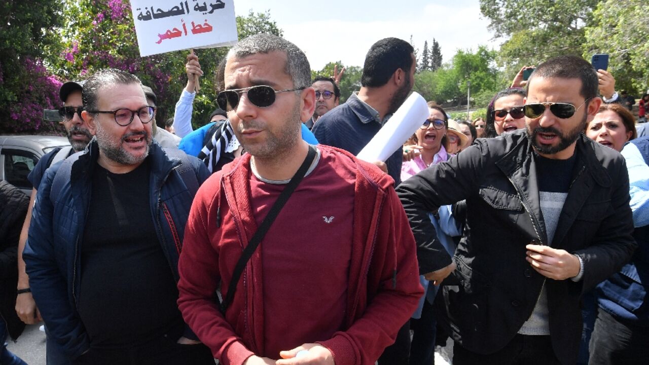 Haythem El Mekki (C) and Elyes Gharbi (L) surrounded by protesters in Tunis Haythem El Mekki (C) and Elyes Gharbi (L) surrounded by protesters in Tunis