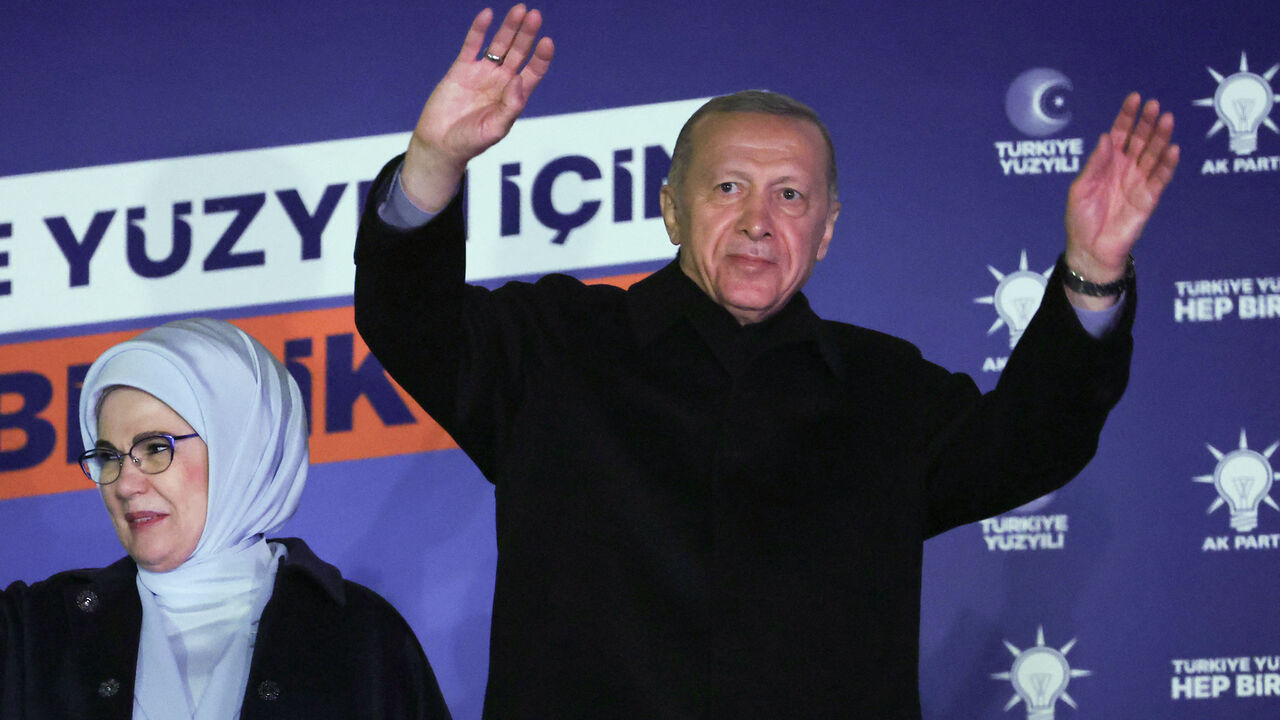 Turkish President Tayyip Erdogan (R), accompanied by his wife Ermine Erdogan (L), waves to supporters at the AK Party headquarters in Ankara, Turkey May 15, 2023.