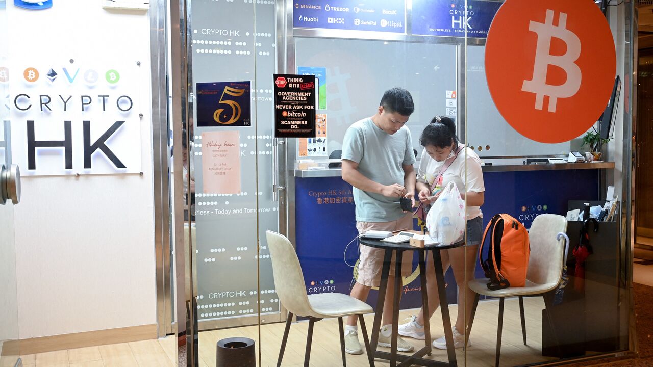 This photo taken on May 27, 2023 shows customers in a cryptocurrency exchange office in Hong Kong. Retail investors in Hong Kong may soon be able to buy popular cryptocurrencies like bitcoin at government-licensed exchanges, thanks to new rules meant to bolster the city's standing as a digital asset hub. (Photo by Peter PARKS / AFP) / TO GO WITH HongKong-China-economy-Cryptocurrency,FOCUS by Holmes CHAN (Photo by PETER PARKS/AFP via Getty Images)