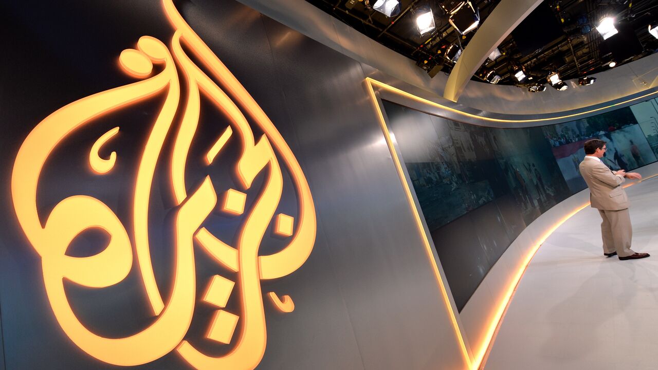  The Al Jazeera logo is seen in the new Al Jazeera America television broadcast studio on West 34th Street August 16, 2013 in New York as Paul Eedle (R), Deputy Launch Manager for Programing speaks to media during a tour. Al Jazeera America, which will launch on August 20, will have its headquarters in New York. AFP PHOTO/Stan HONDA (Photo credit should read STAN HONDA/AFP via Getty Images)