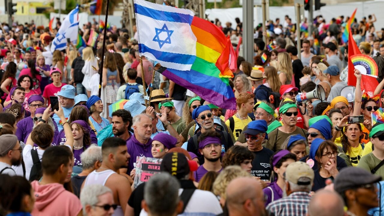 People march with rainbow and Israeli flags during the annual Pride Parade in Tel Aviv People march with rainbow and Israeli flags during the annual Pride Parade in Tel Aviv