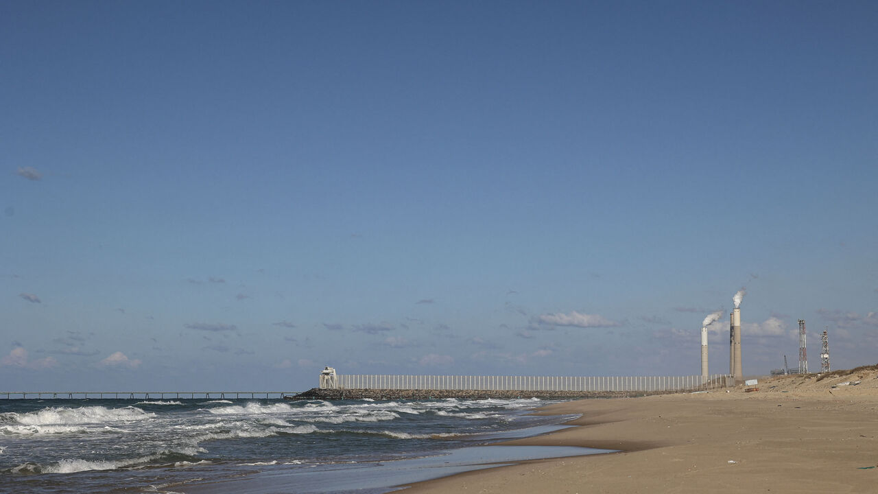 A picture shows the beach in the town of Beit Lahia with a view of the towers of an Israeli power plant in the city of Askelon, northern Gaza Strip, Dec. 15, 2021.