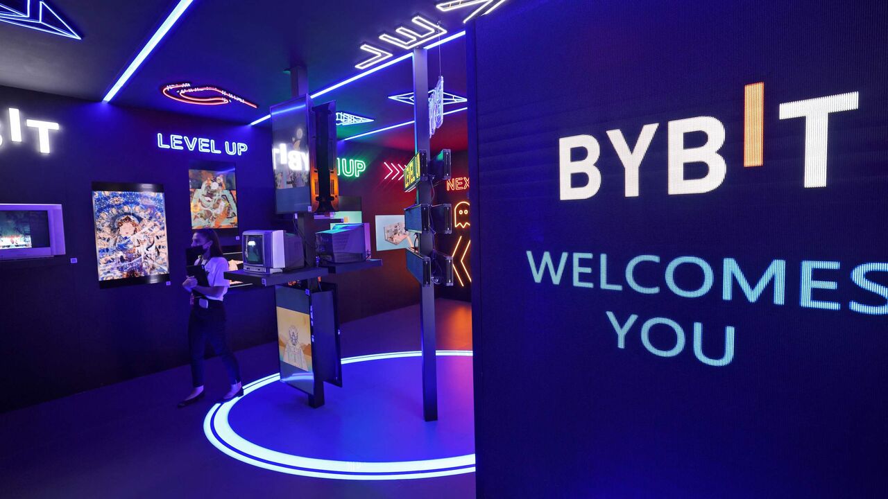 Visitors stand in front of works by Bybit on display during the 15th edition of Art Dubai at Madinat Jumeirah in the Gulf emirate of Dubai, on March 10, 2022. - Art Dubai, the Middle East's largest annual contemporary art fair, featured for the first time digital works, as the wealthy Gulf emirate seeks to position itself as a crypto-assets hub. - RESTRICTED TO EDITORIAL USE - MANDATORY MENTION OF THE ARTIST UPON PUBLICATION - TO ILLUSTRATE THE EVENT AS SPECIFIED IN THE CAPTION (Photo by Karim SAHIB / AFP)
