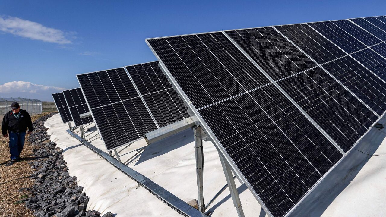 An Israeli worker walks between solar panel rows laid out at a farm on the outskirts of Moshav Haspin in the Israel-annexed Golan Heights near the border with Syria on January 8, 2023. (Photo by JALAA MAREY / AFP) (Photo by JALAA MAREY/AFP via Getty Images)