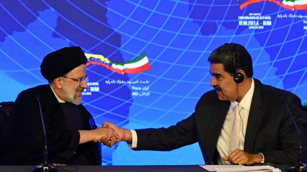 Iranian President Ebrahim Raisi (L) and Venezuelan President Nicolas Maduro shake hands during a joint press statement at Miraflores Presidential Palace in Caracas Iranian President Ebrahim Raisi (L) and Venezuelan President Nicolas Maduro shake hands during a joint press statement at Miraflores Presidential Palace in Caracas