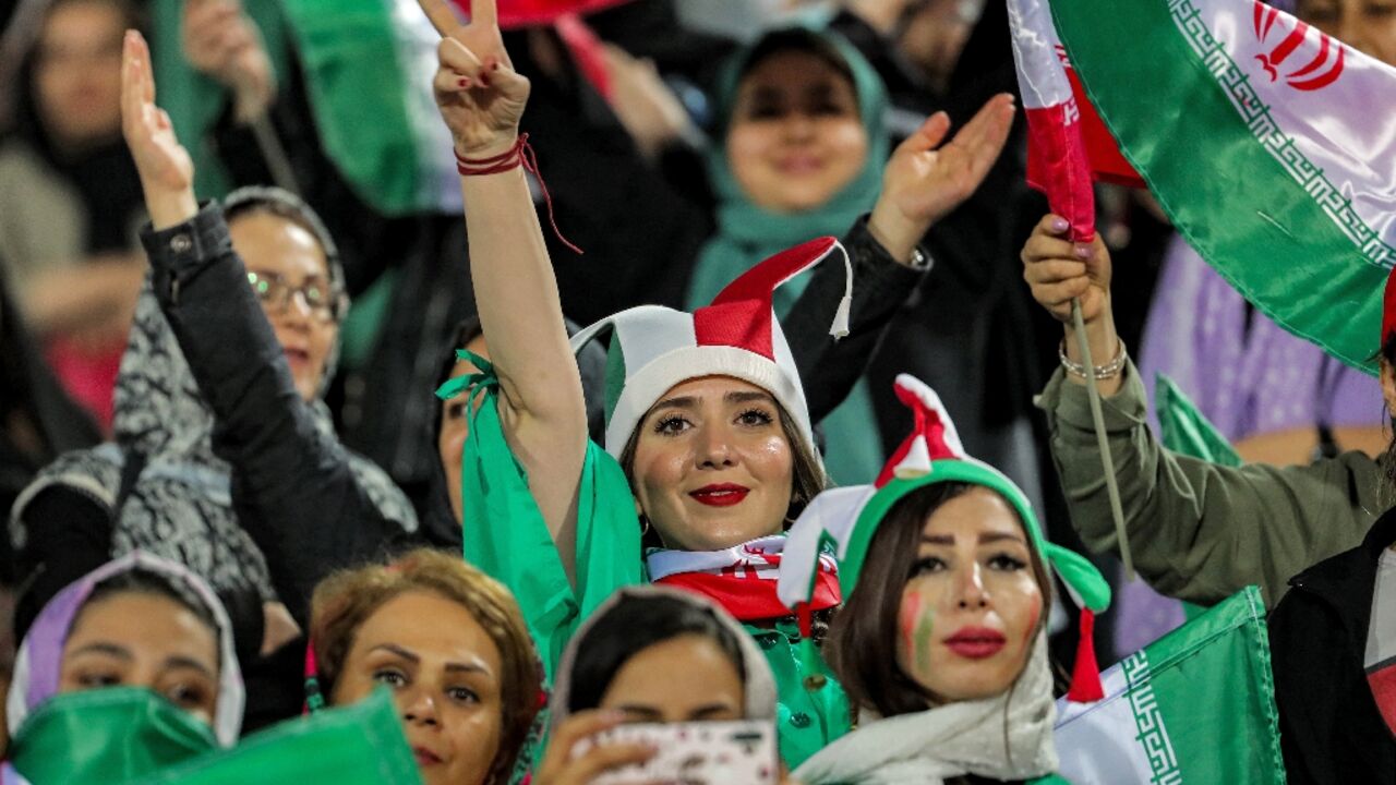 Women football fans wave national flags and cheer during a friendly match between Iran and Kenya in Tehran in March Women football fans wave national flags and cheer during a friendly match between Iran and Kenya in Tehran in March