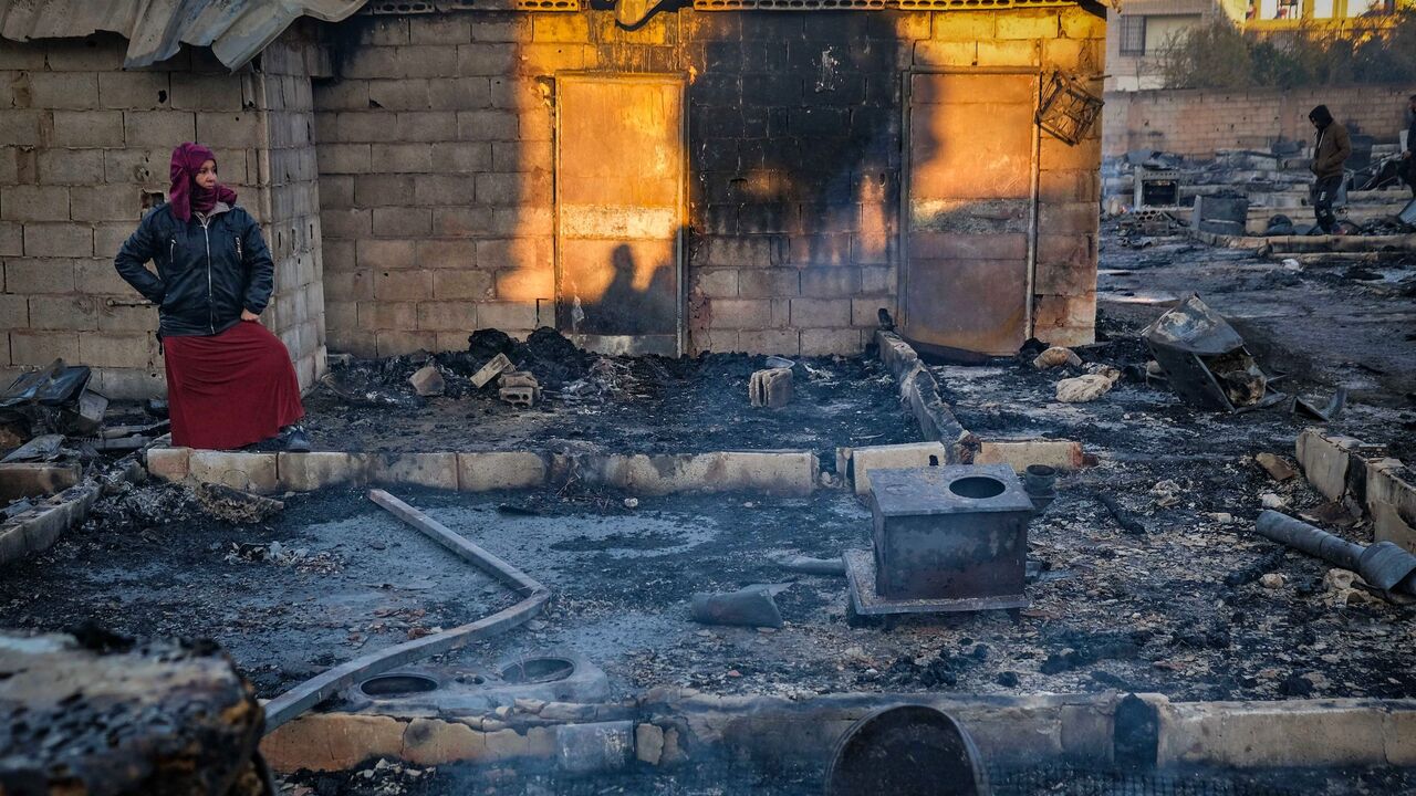 Syrian refugees salvage belongings from the wreckage of their shelters at a camp set on fire overnight in the northern Lebanese town of Bhanine on Dec. 27, 2020.