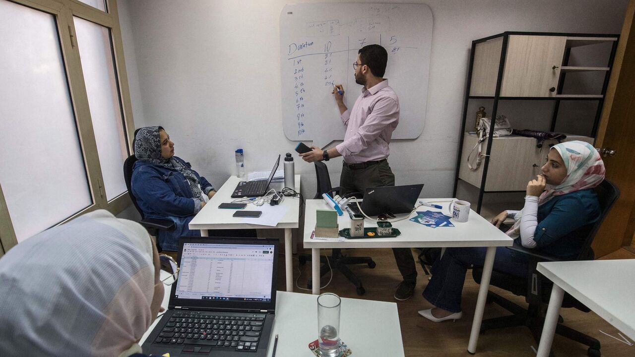 This picture taken on September 12, 2021 shows a view of the company offices of "al-Gameya", a tech startup the runs an app to facilitate for strangers to create an informal money-pooling association to provide access for money in time of need, points a screen showing to the application's online portal at the company offices, in Egypts capital Cairo. - Cash-strapped Egyptians fearful of banks have long relied on a "gameya" to access money in time of need, but now tech startups are cashing in on the practice