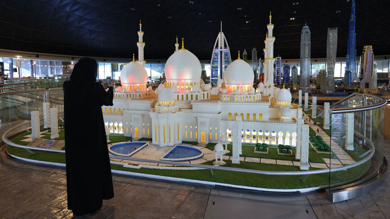 A woman takes a photo of the LEGO-made Sheikh Zayed Grand Mosque miniature at Dubai's LEGOLAND theme park, on March 7, 2022. - Over 60 million LEGO bricks are in MINILAND, where LEGOLAND Dubai has recreated scenes and famous landmarks from the UAE and Middle East region, including Burj Khalifa, Burj Al Arab, the Sheikh Zayed Grand Mosque. (Photo by Giuseppe CACACE / AFP) (Photo by GIUSEPPE CACACE/AFP via Getty Images)