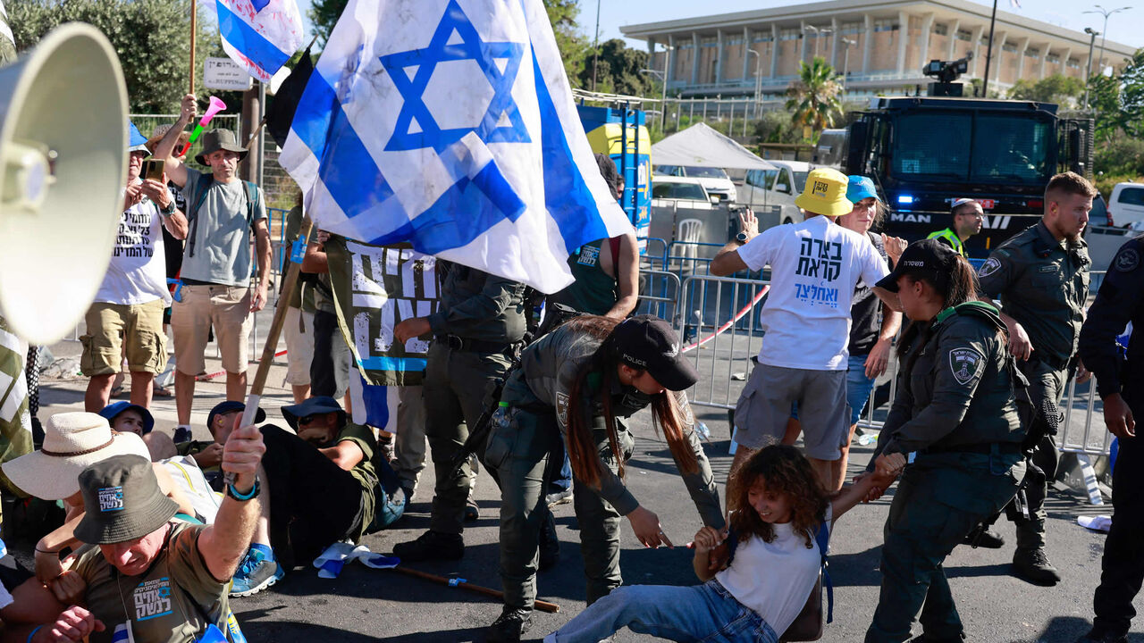 Members of Israel's security forces remove protesters blocking the Knesset entrance amid a monthslong wave of protests against the government's planned judicial overhaul, Jerusalem, July 24, 2023.