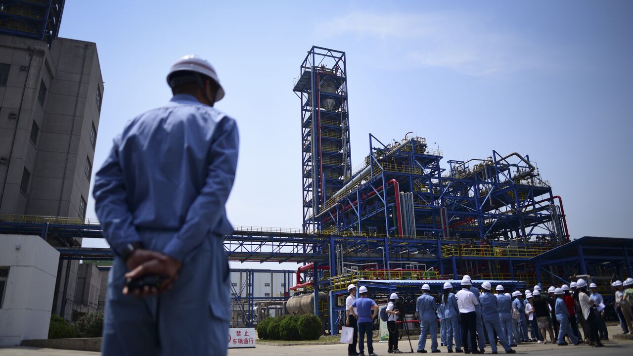 A Sinopec employee looks at a group of jounalists visiting Polypropylene Plant No3 of the Sinopec Yanshan Petrochemical Company (SYPC) during a tour arranged by the State Council Information Office in Beijing on May 25, 2018. (Photo by WANG Zhao / AFP) (Photo credit should read WANG ZHAO/AFP via Getty Images)