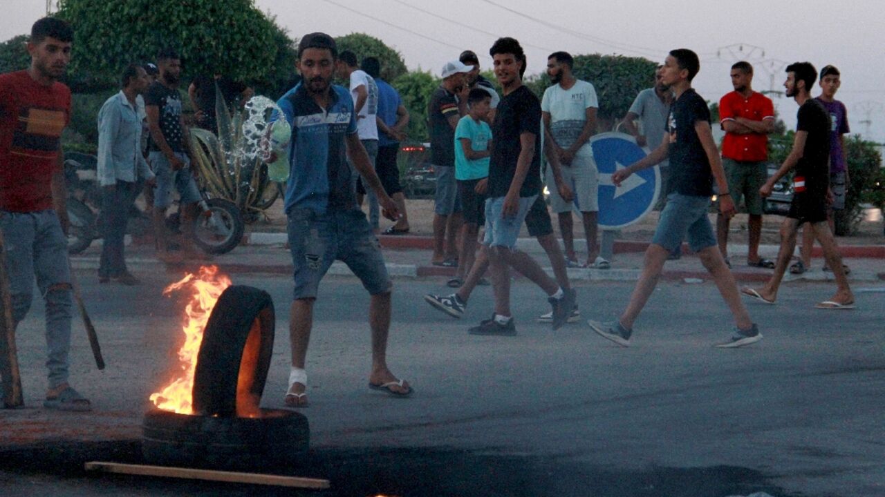 Tunisian youths block a road and set tyres on fire amid hih tensions in Sfax on July 4, 2023 after the burial of a young Tunisian stabbed to death during a scuffle between residents and migrants from sub-Saharan Africa Tunisian youths block a road and set tyres on fire amid hih tensions in Sfax on July 4, 2023 after the burial of a young Tunisian stabbed to death during a scuffle between residents and migrants from sub-Saharan Africa