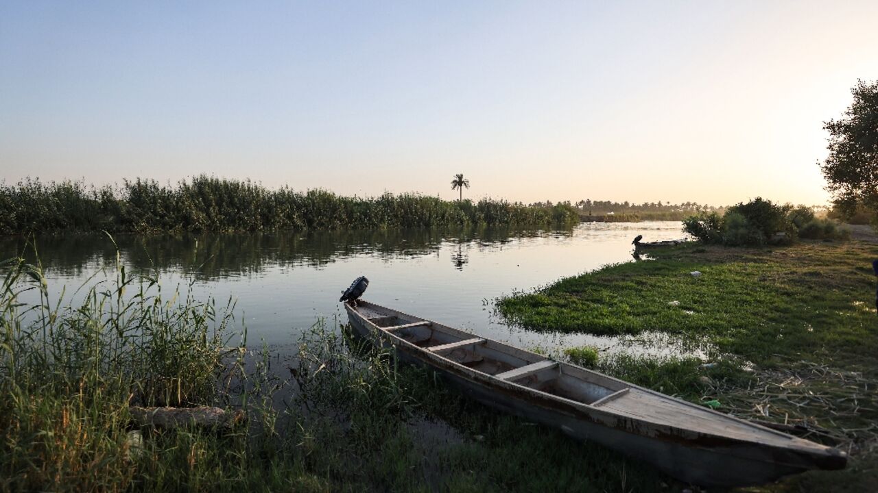 A fishing boat is moored on the banks of a branch of the Euphrates River in the Iraqi town of Al-Hamza