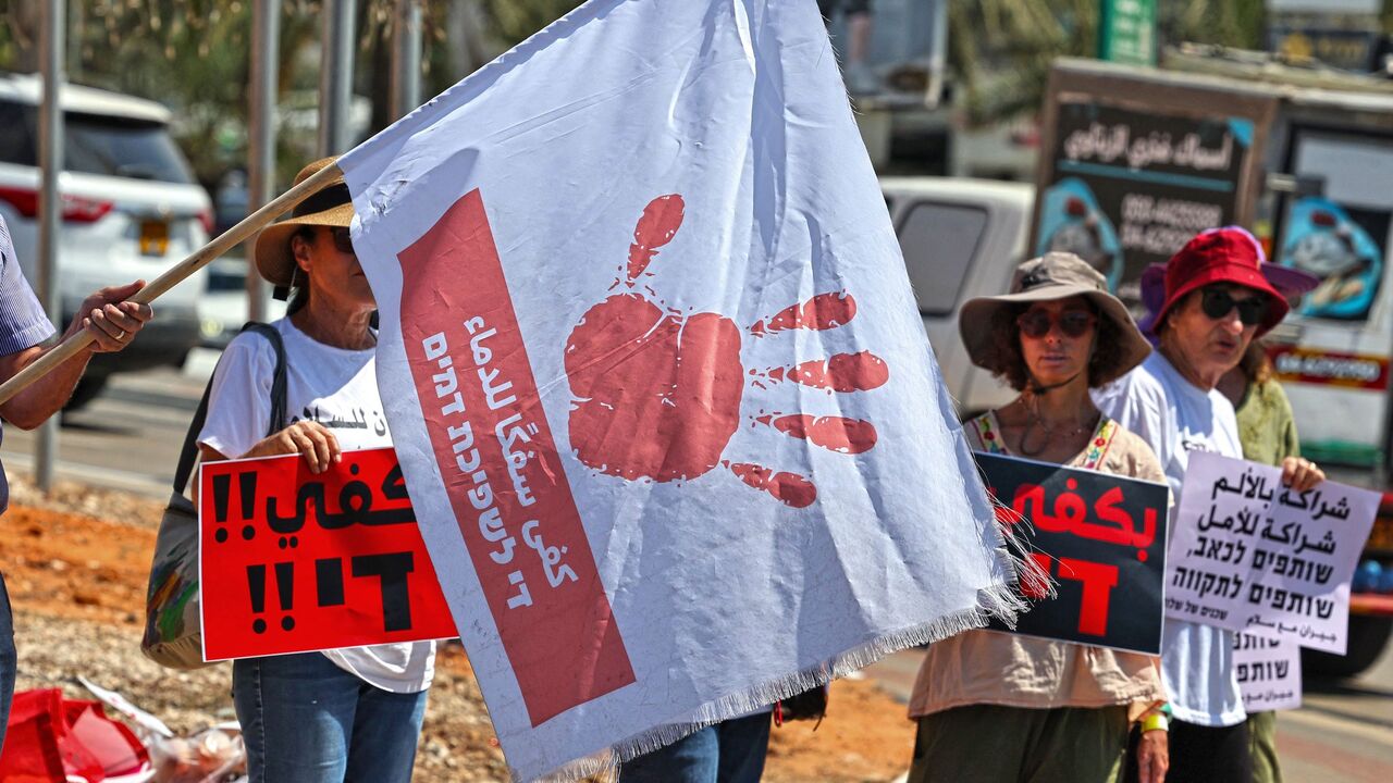 Arab Israeli citizens and activists lift placards at a rally in the mostly Arab northern city of Umm al-Fahm.