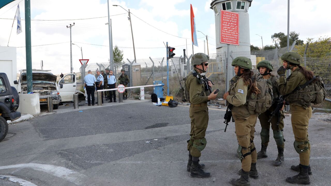 Israeli soldiers stand guard as police check a car damaged in a reported ramming attack at the Bell checkpoint near the settlement of Beit Horon, on the occupied West Bank, east of the central Israeli city of Modiin, November 2, 2022.