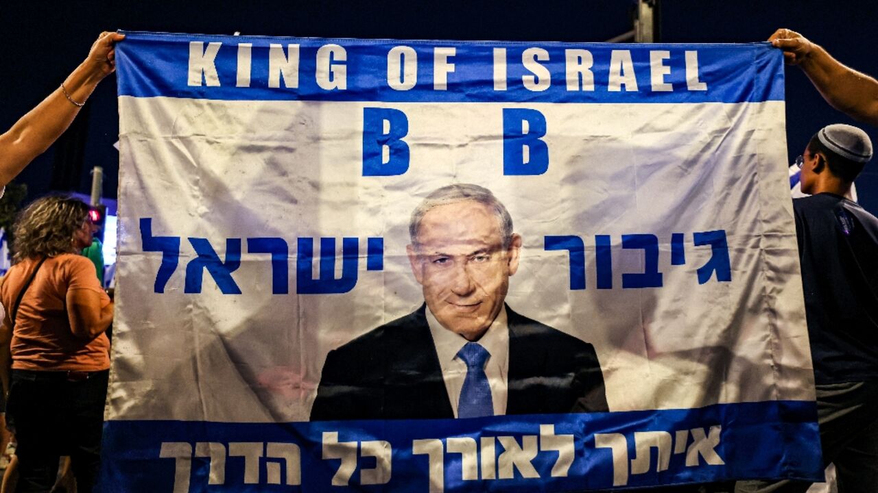 Demonstrators hold a banner showing an image of Israel's Prime Minister Benjamin Netanyahu during a rally in Jerusalem