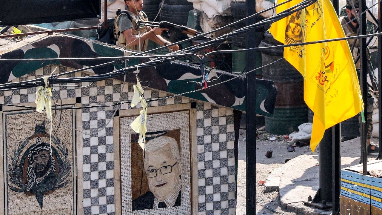 A fighter of the Palestinian Fatah movement takes cover during clashes in the Ain al-Helweh camp for Palestinian refugees in Lebanon's southern coastal city of Sidon on September 10, 2023