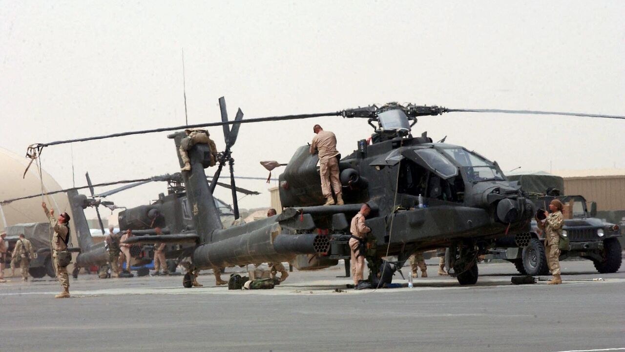 US Army helicopter crew from the 101st Airborne Division prepares the Apache attack helicopter at the the Camp Udairi airfield in preparation for a mission to Iraq 20 March 2003.