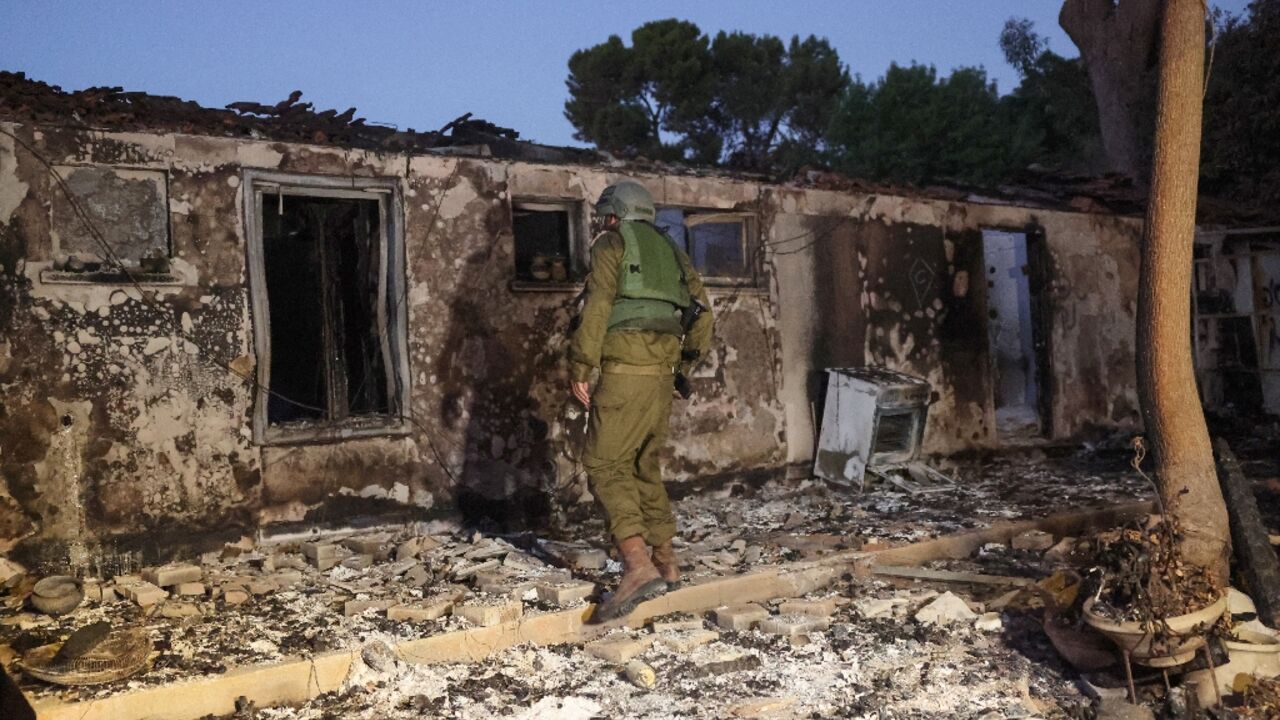 A member of Israel's security forces inspects a damaged building at kibbutz Beeri near the border with Gaza which was overrun by Hamas militants Saturday when they launched a shock surprise attack on Israel A member of Israel's security forces inspects a damaged building at kibbutz Beeri near the border with Gaza which was overrun by Hamas militants Saturday when they launched a shock surprise attack on Israel