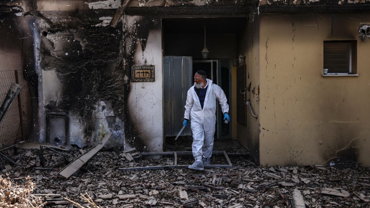 A volunteer of the Zaka emergency response team searches through the debris in Kibbutz Beeri near the border with Gaza on October 20, 2023