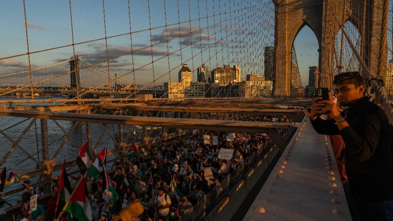 People cross the Brooklyn Bridge as they take part in a protest in support of the Palestinian people