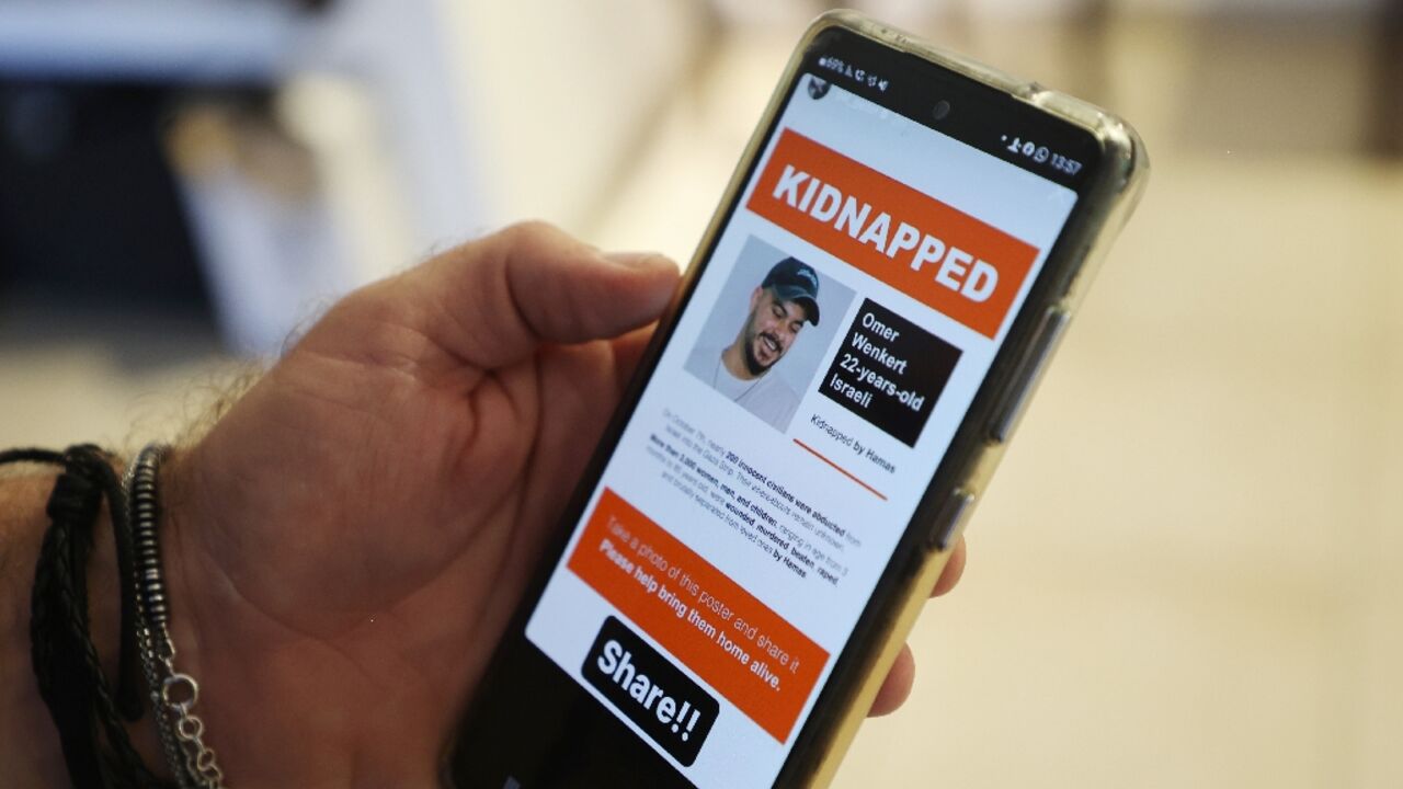 Shay Wenkert, the father of Israeli hostage Omer Wenkert who Hamas gunmen abducted from a music festival, shows an image of his son on a phone Shay Wenkert, the father of Israeli hostage Omer Wenkert who Hamas gunmen abducted from a music festival, shows an image of his son on a phone