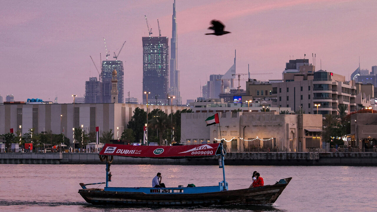 A bird flies past a boat sailing along Dubai creek in the Gulf emirate on May 2, 2021 while the Burj Khalifa skyscraper is seen in the background. (Photo by GIUSEPPE CACACE / AFP) (Photo by GIUSEPPE CACACE/AFP via Getty Images)