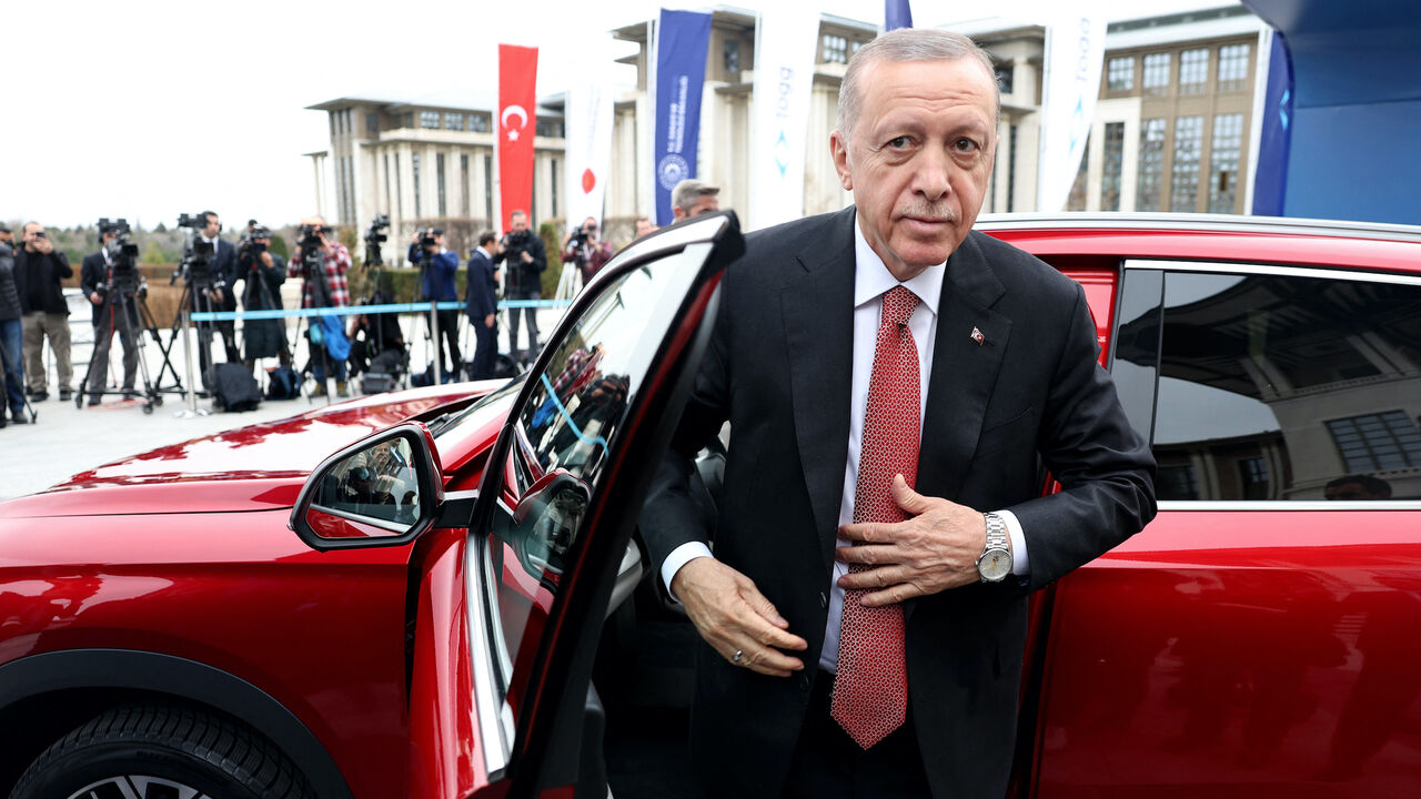 Turkey's President Recep Tayyip Erdogan stands next to his Togg T10X, Turkey's first domestically-produced electric car, after receiving it from the company at the Presidential Complex in Ankara, on April 3, 2023. (Photo by Adem ALTAN / AFP) (Photo by ADEM ALTAN/AFP via Getty Images)