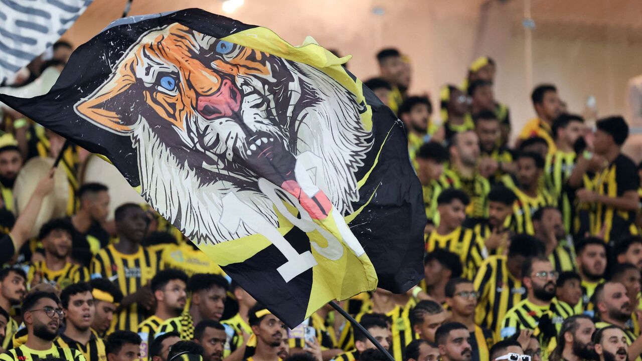 Al-Ittihad's supporters wave a flag.